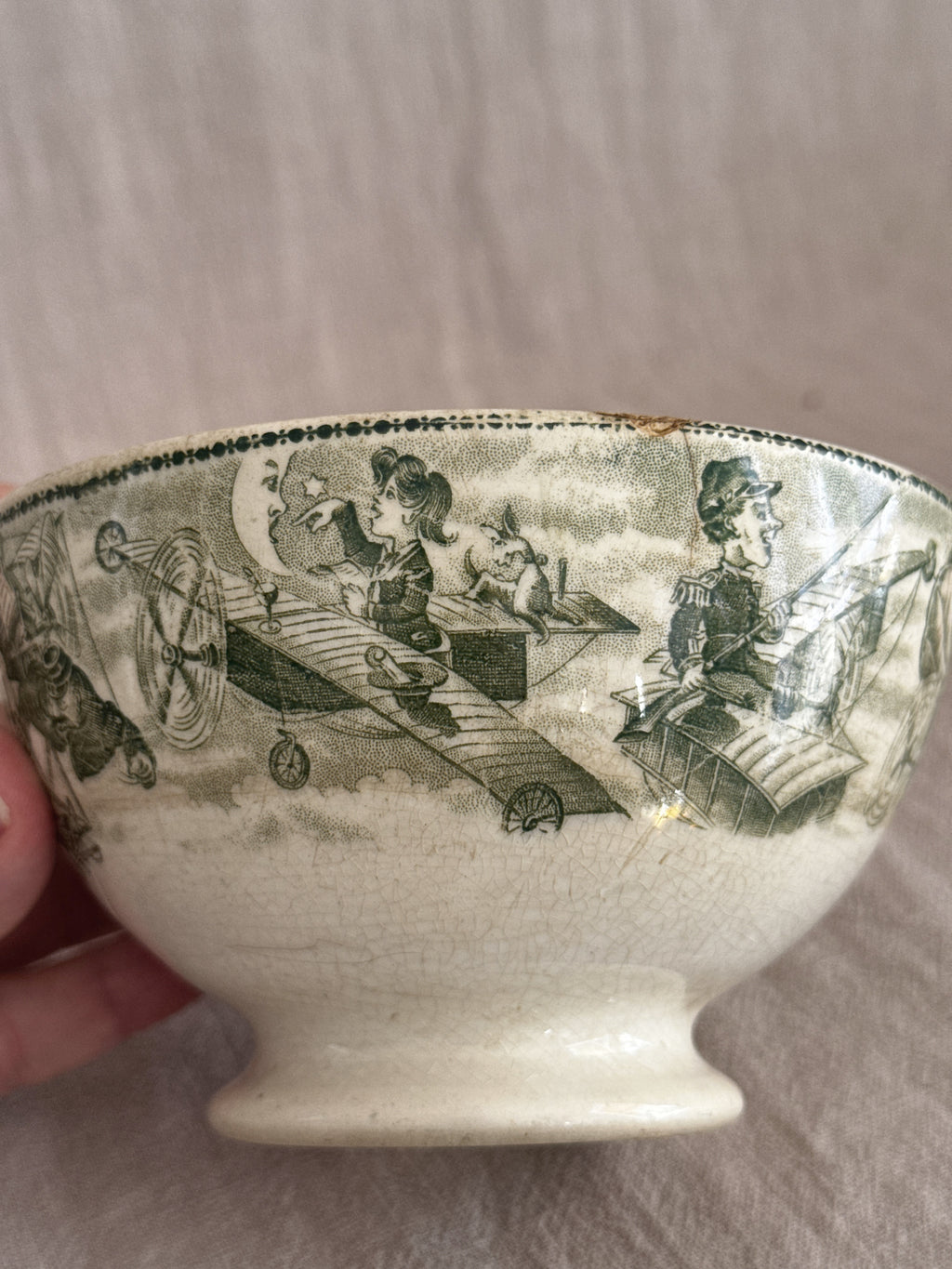 The bowl held in hand showing a monoplane and pilot in the green printed band
