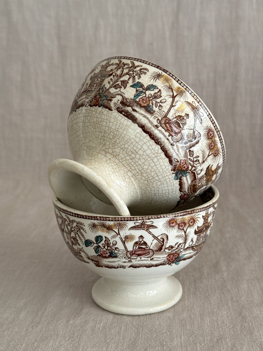 The pair tipped to show the printed bands and the pedestal feet