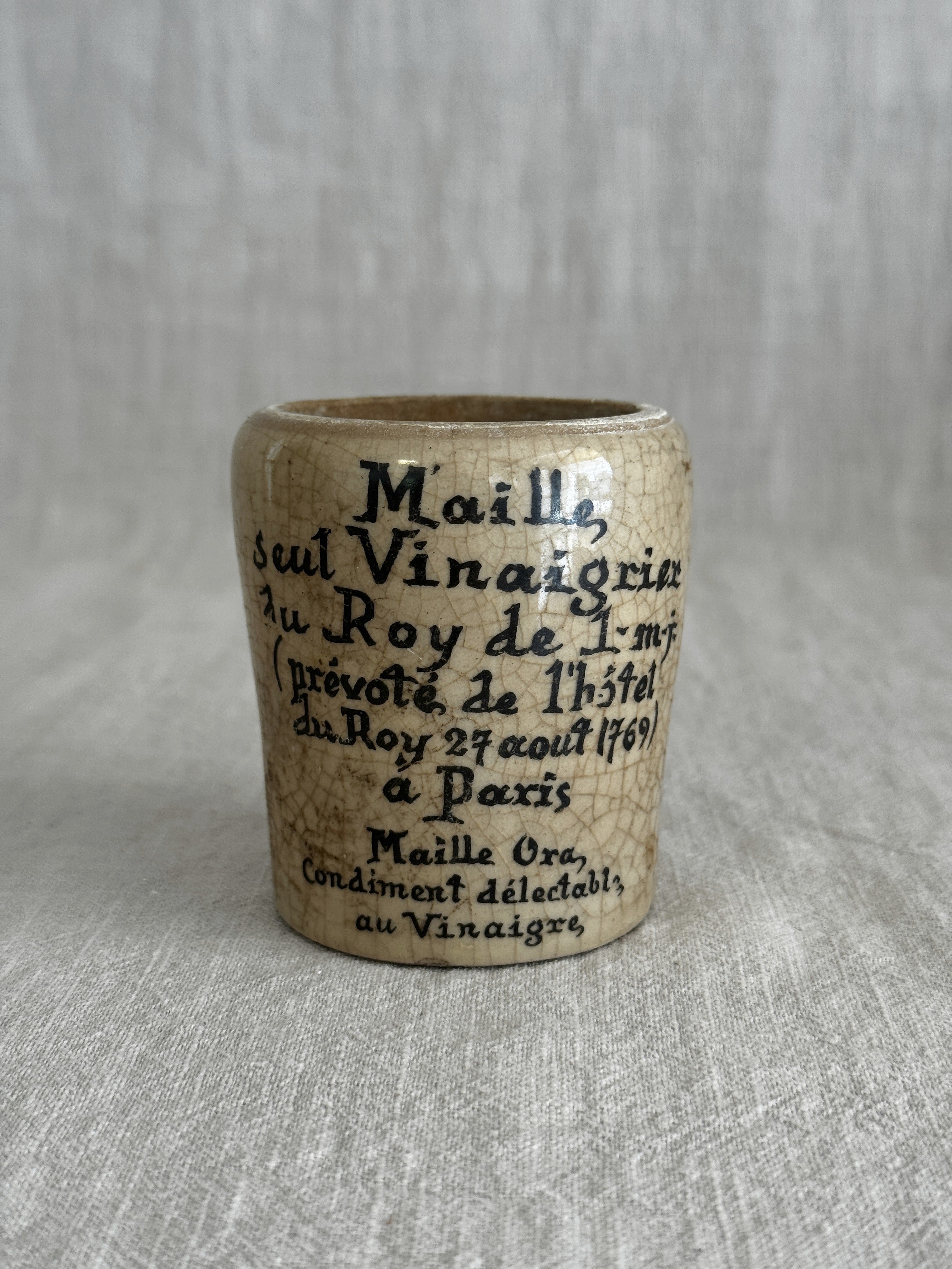 Close view of the ochre glazed pot showing the printed text and warm yellow glaze