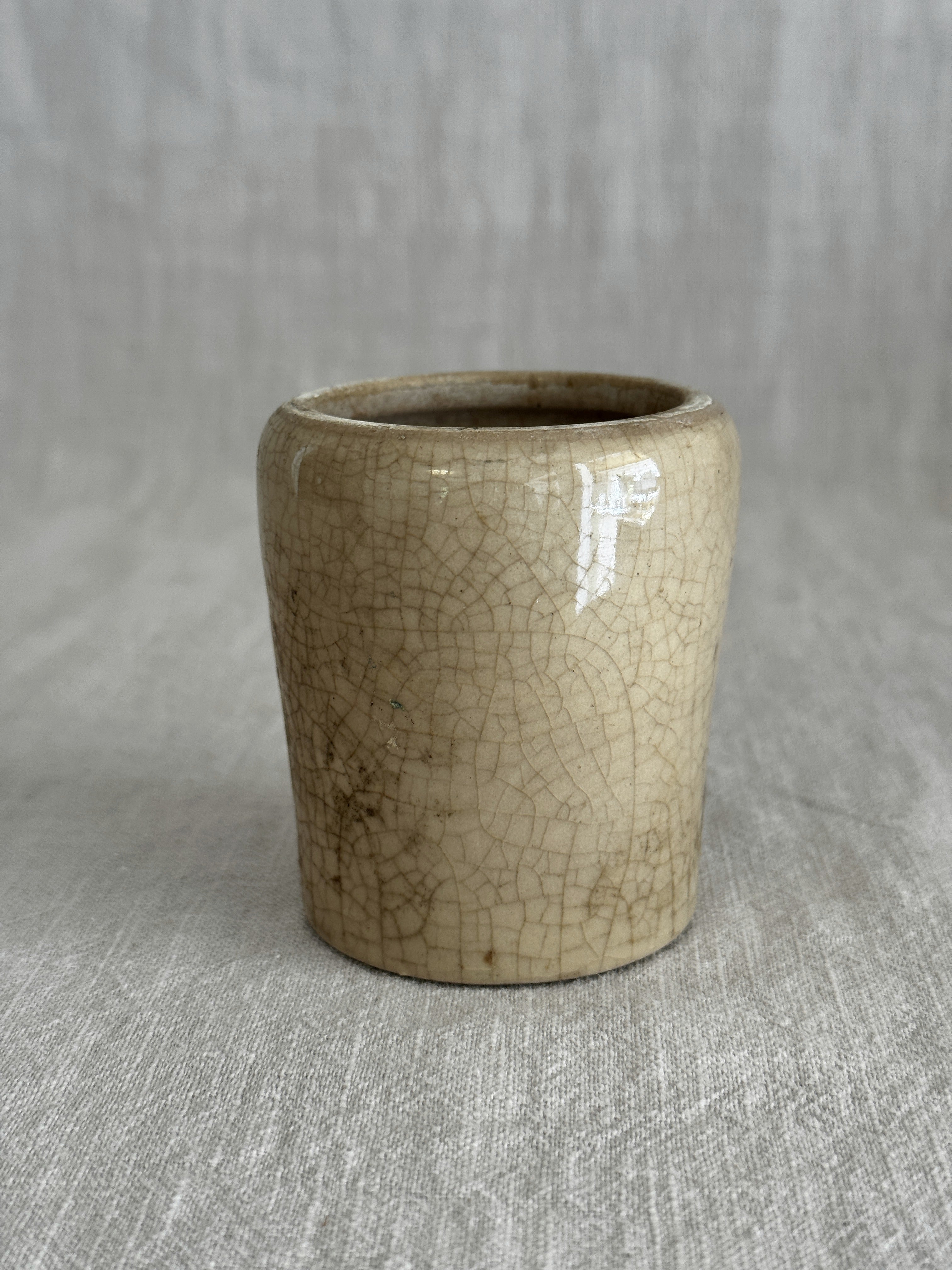 The cream pot standing alone, showing the even crazing across the unglazed body
