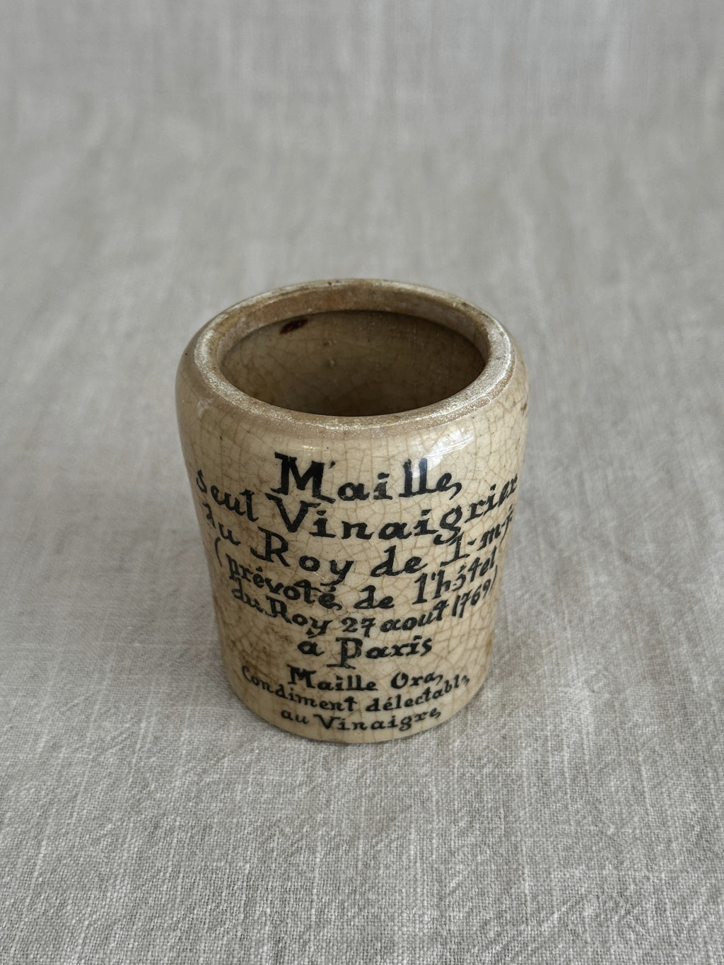 The cream Maille pot photographed close, showing the crisp printed text and patina