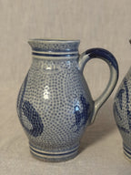 Side view of one jug showing the loop handle and cobalt banding at the collar