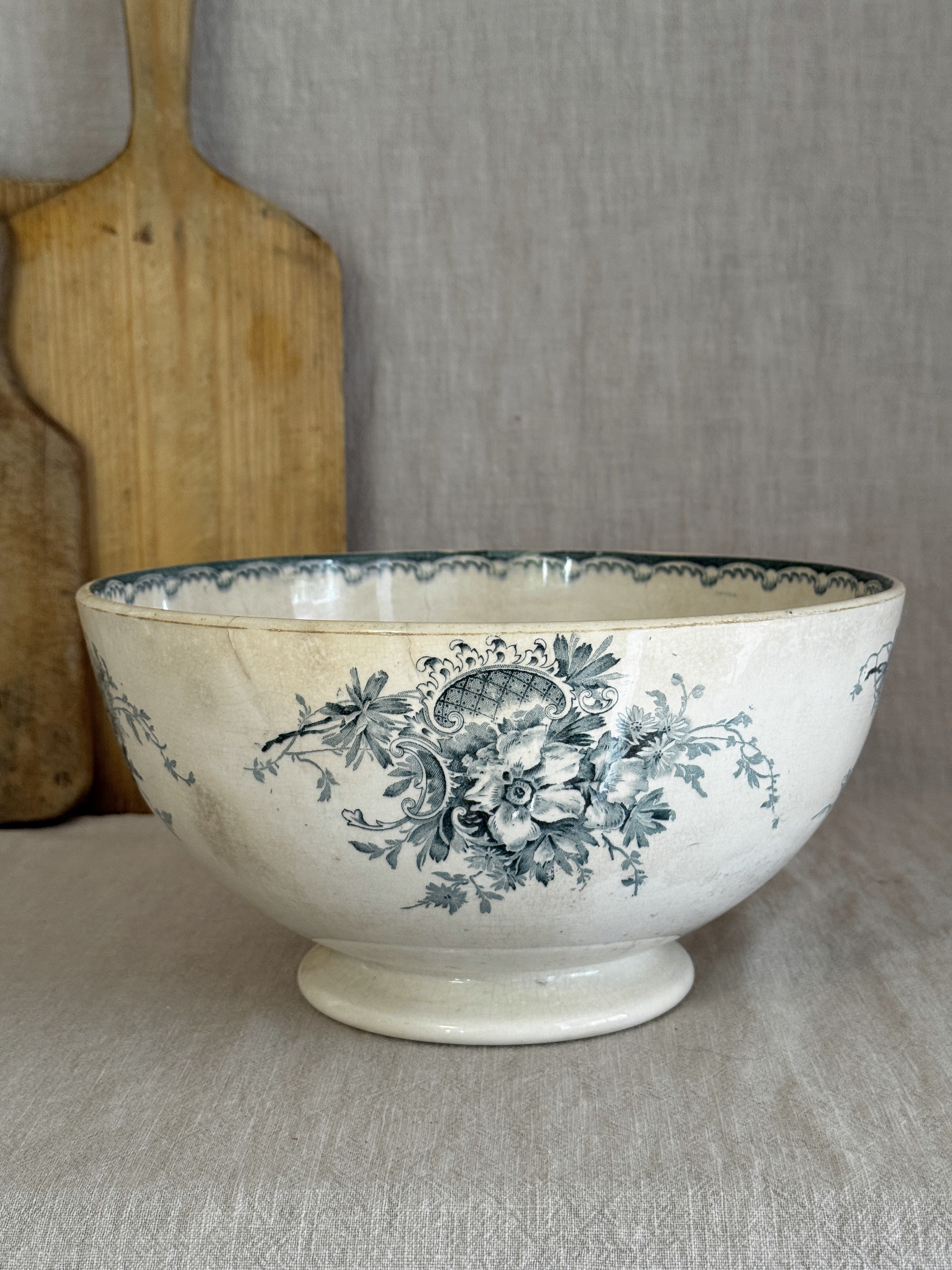 Antique Swedish Anna footed bowl in blue-green transferware, seen from the side against a rustic wooden board