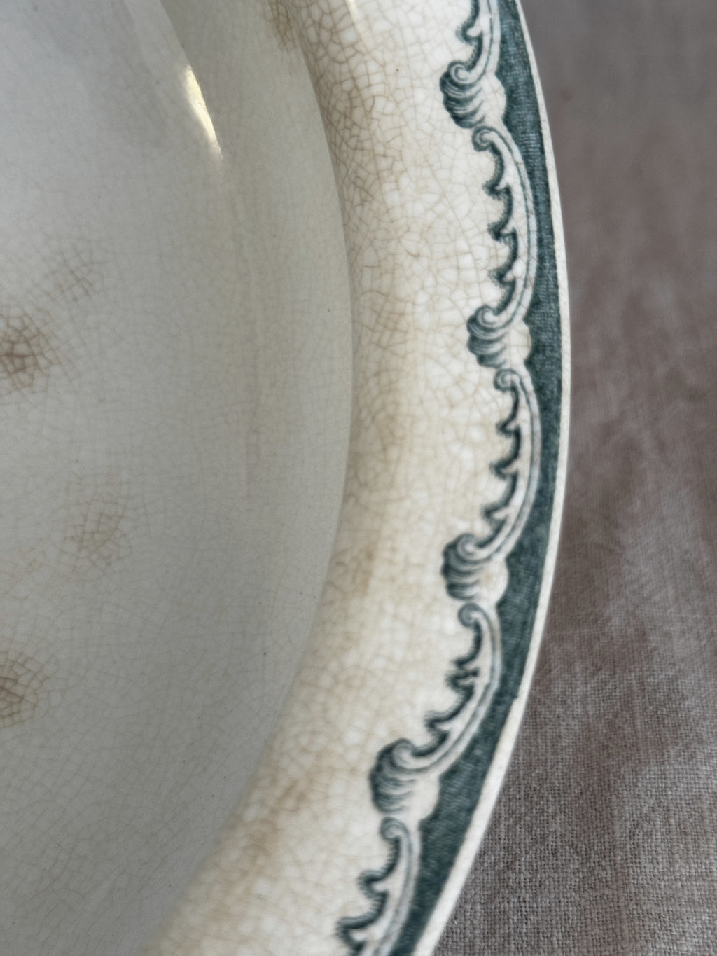 Close view of the scrolled rim border on the antique Swedish Anna bowl, with even crazing across the glaze