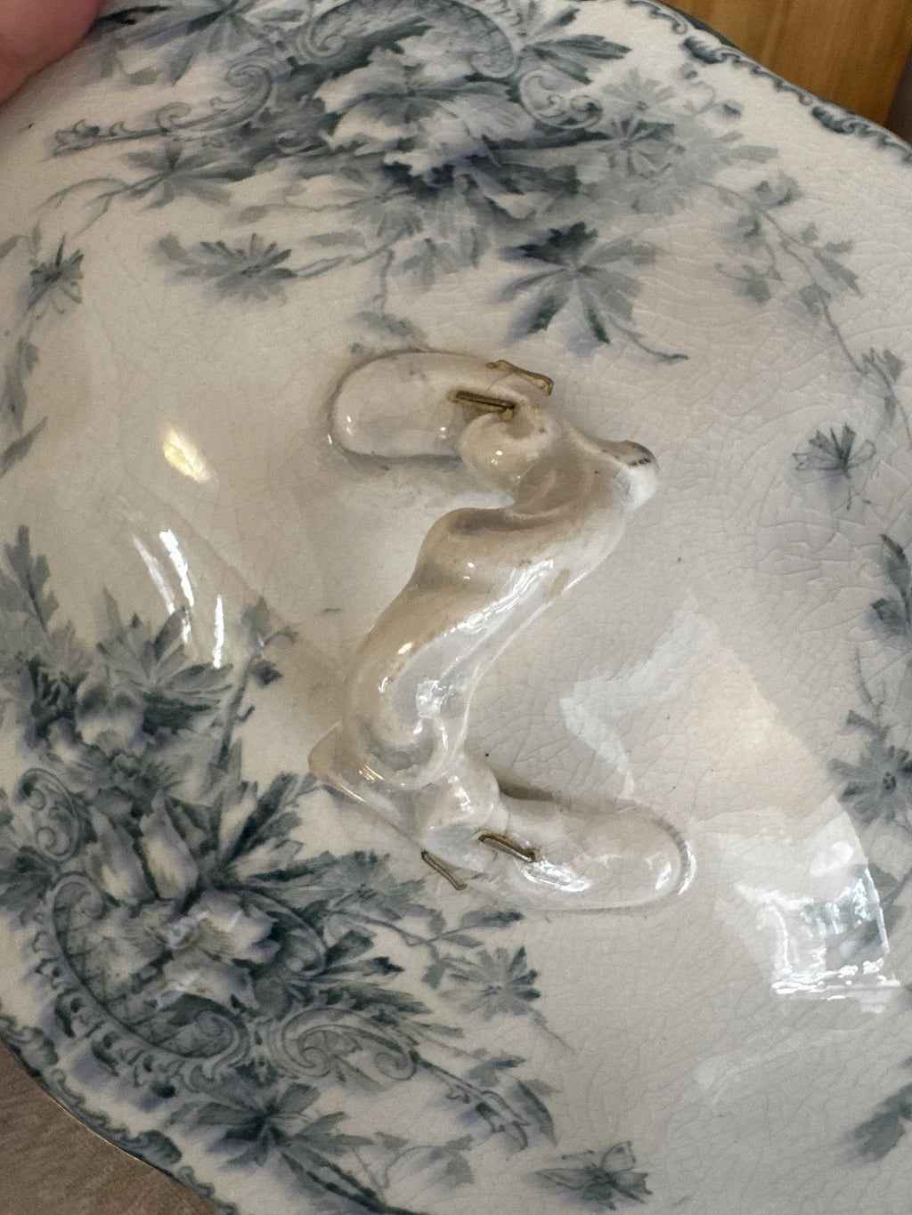 Branch finial with four metal staples on the teal floral transferware lid