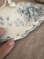 Wave-cut edge of the tureen lid showing the glaze, crazing and teal floral transfer