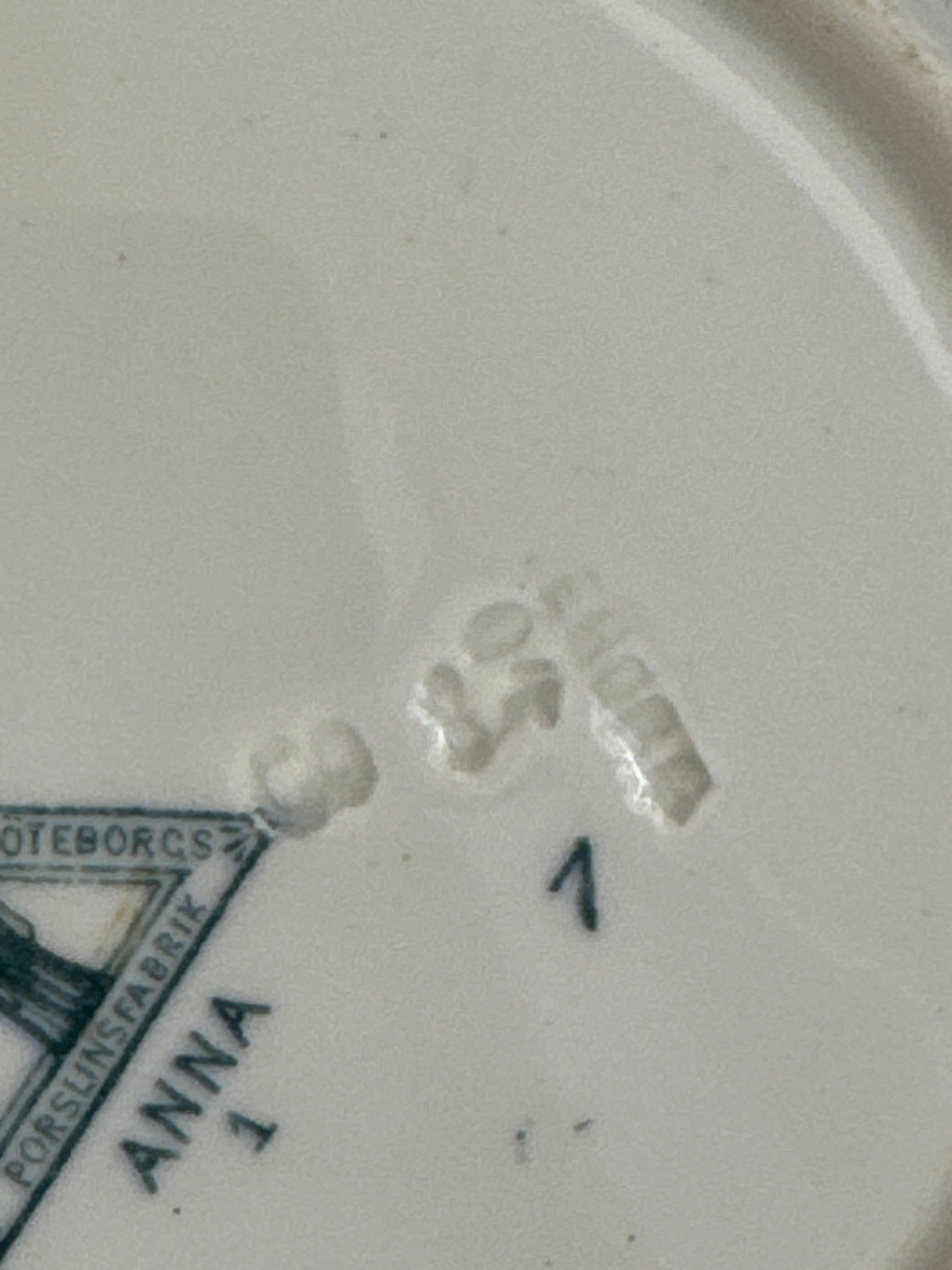 Close view of the printed ANNA mark and the impressed marks on the underside