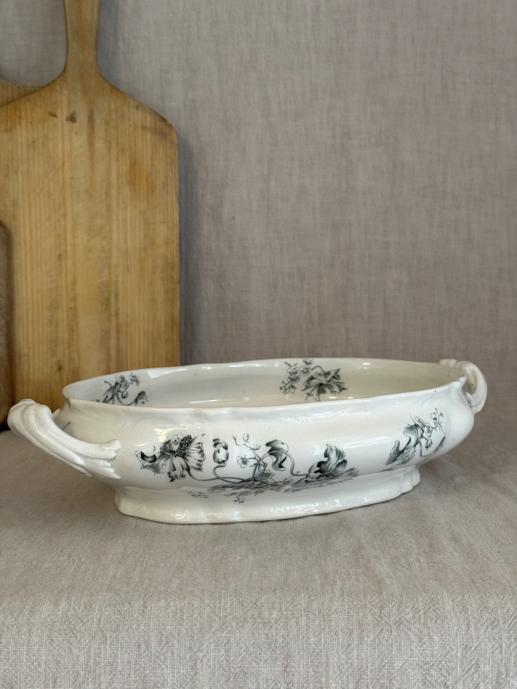 Low oval Rörstrand Papaver footed bowl with leaf-scroll handles, seen from the side on linen