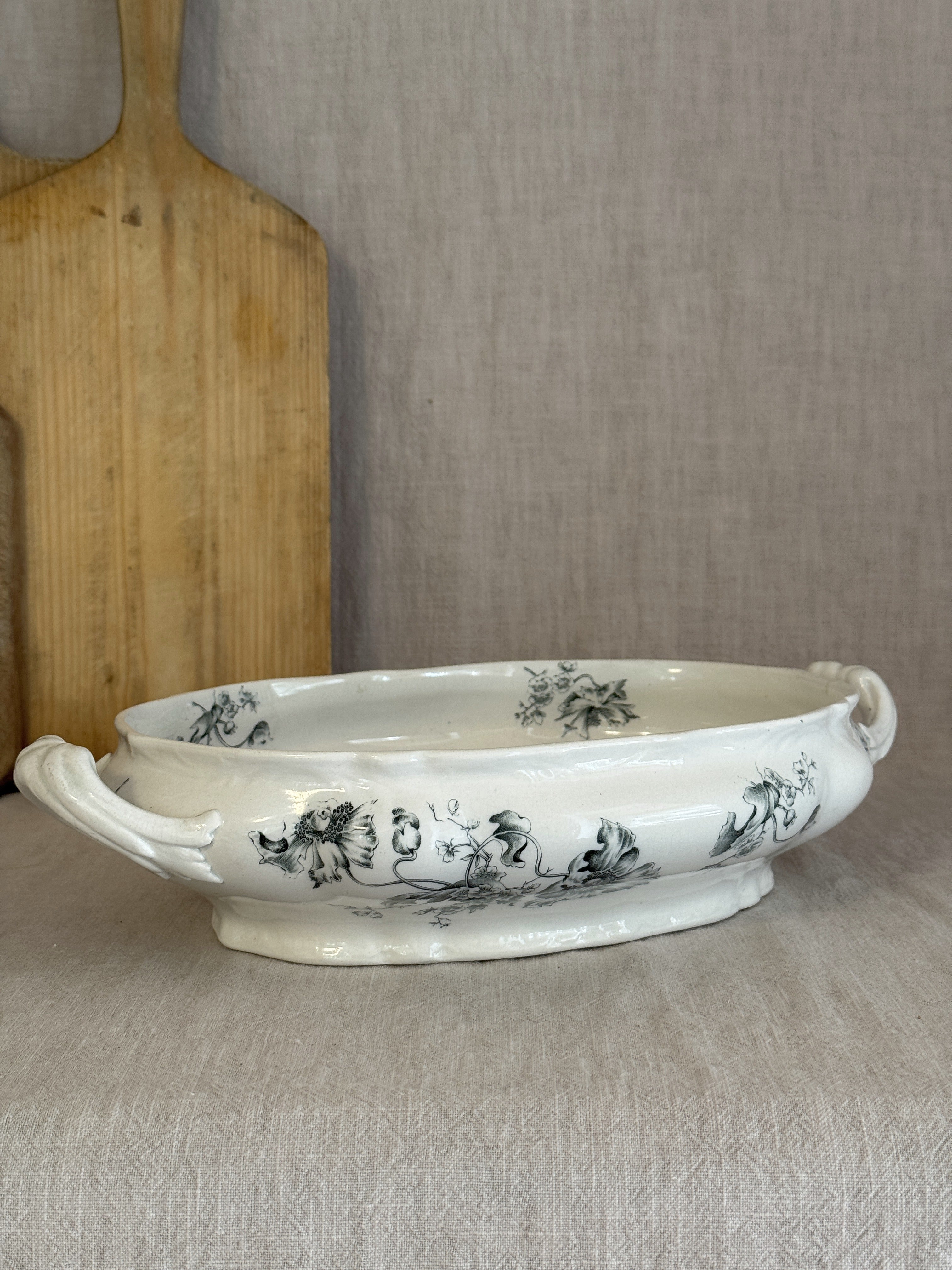 Low oval Rörstrand Papaver footed bowl with leaf-scroll handles, seen from the side on linen