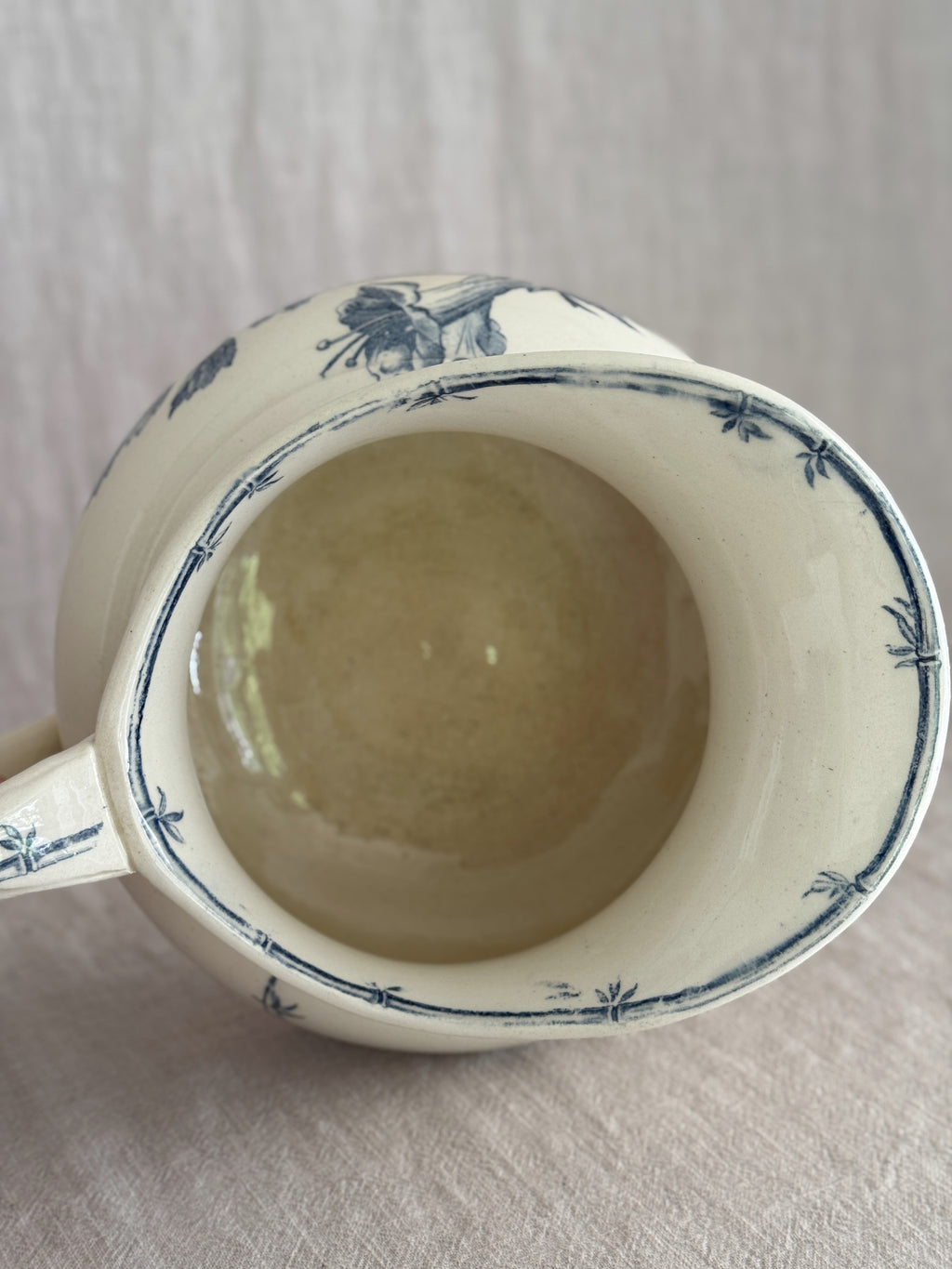 Looking down into the jug showing the honey-toned interior glaze and the bamboo border painted around the inner rim