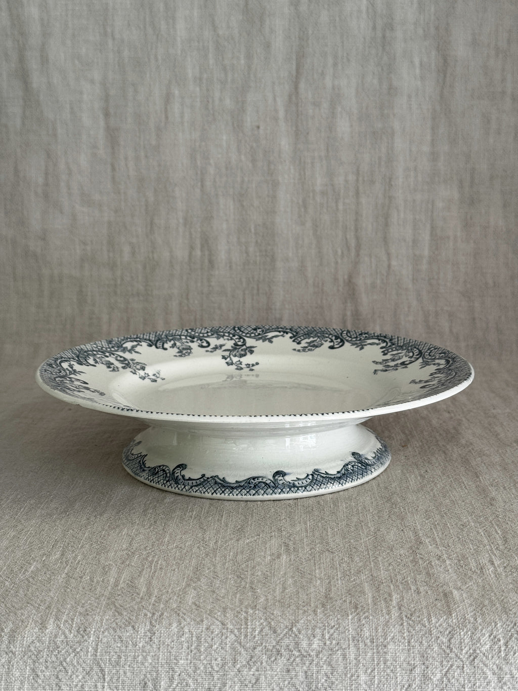 Side view of the footed compotier, showing the pedestal foot with its matching blue-grey scroll and trellis band