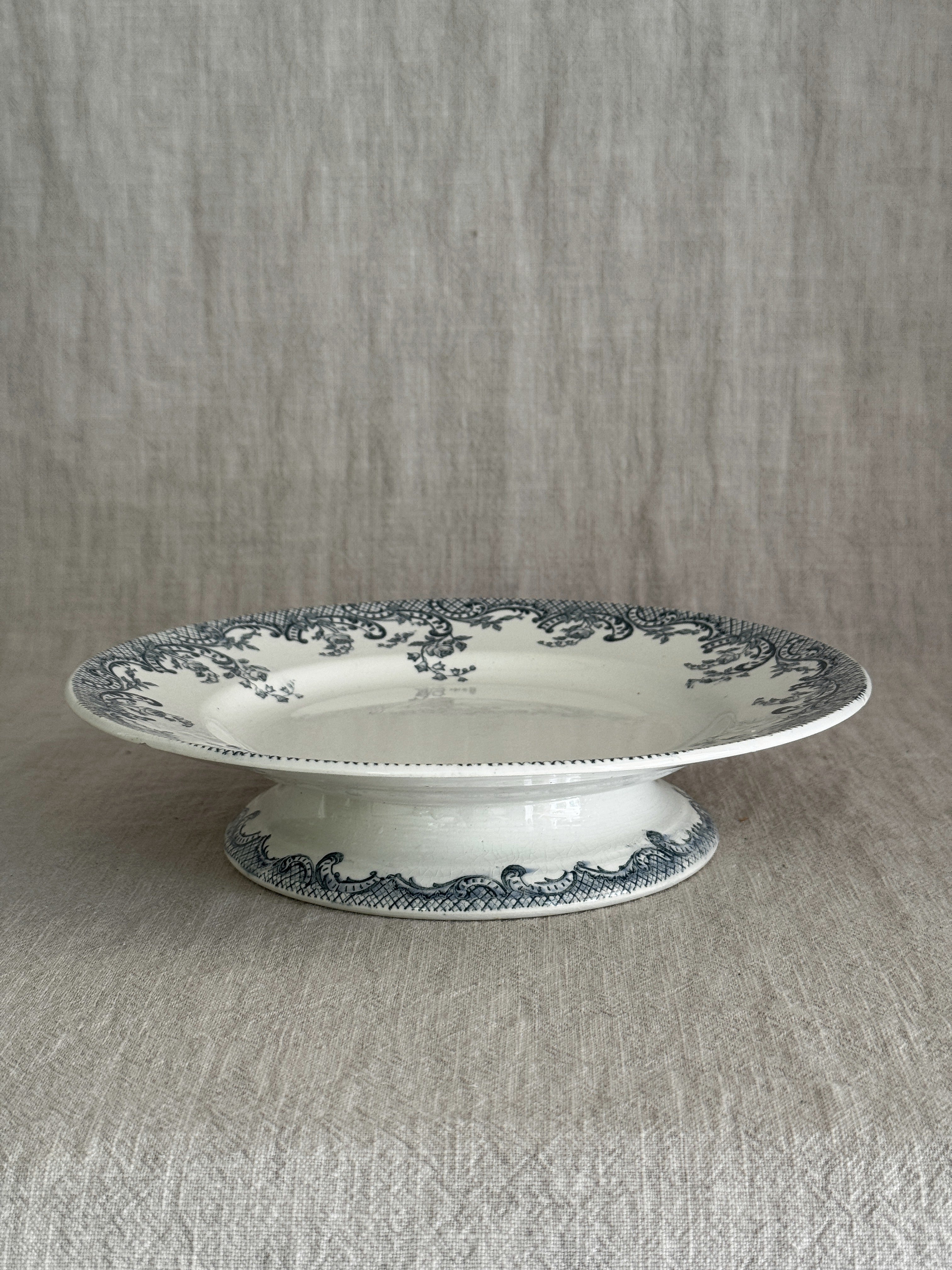 Side view of the footed compotier, showing the pedestal foot with its matching blue-grey scroll and trellis band