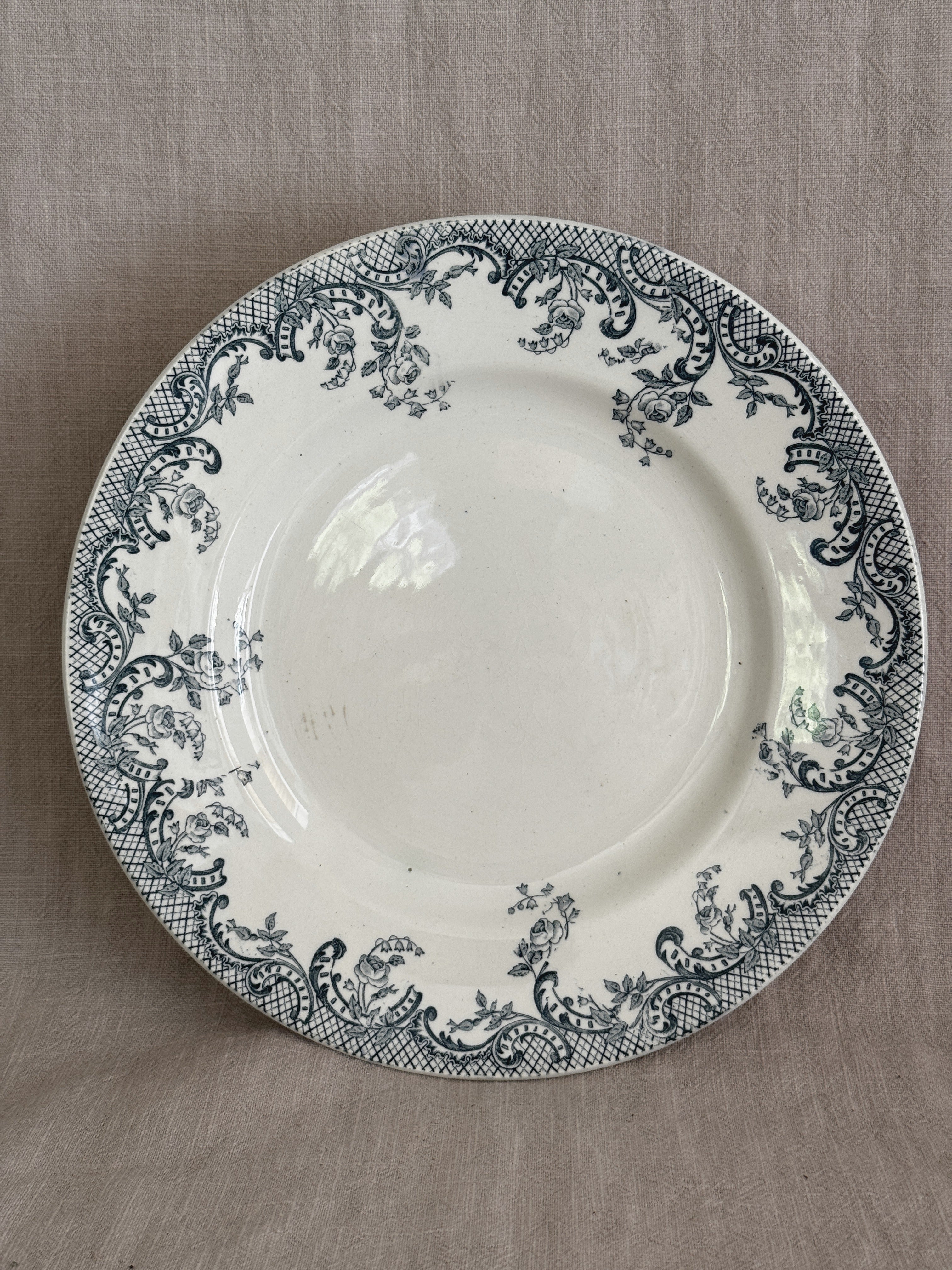 Overhead view of the compotier with the wide rim filled with blue-grey rococo scrollwork, roses and bellflowers