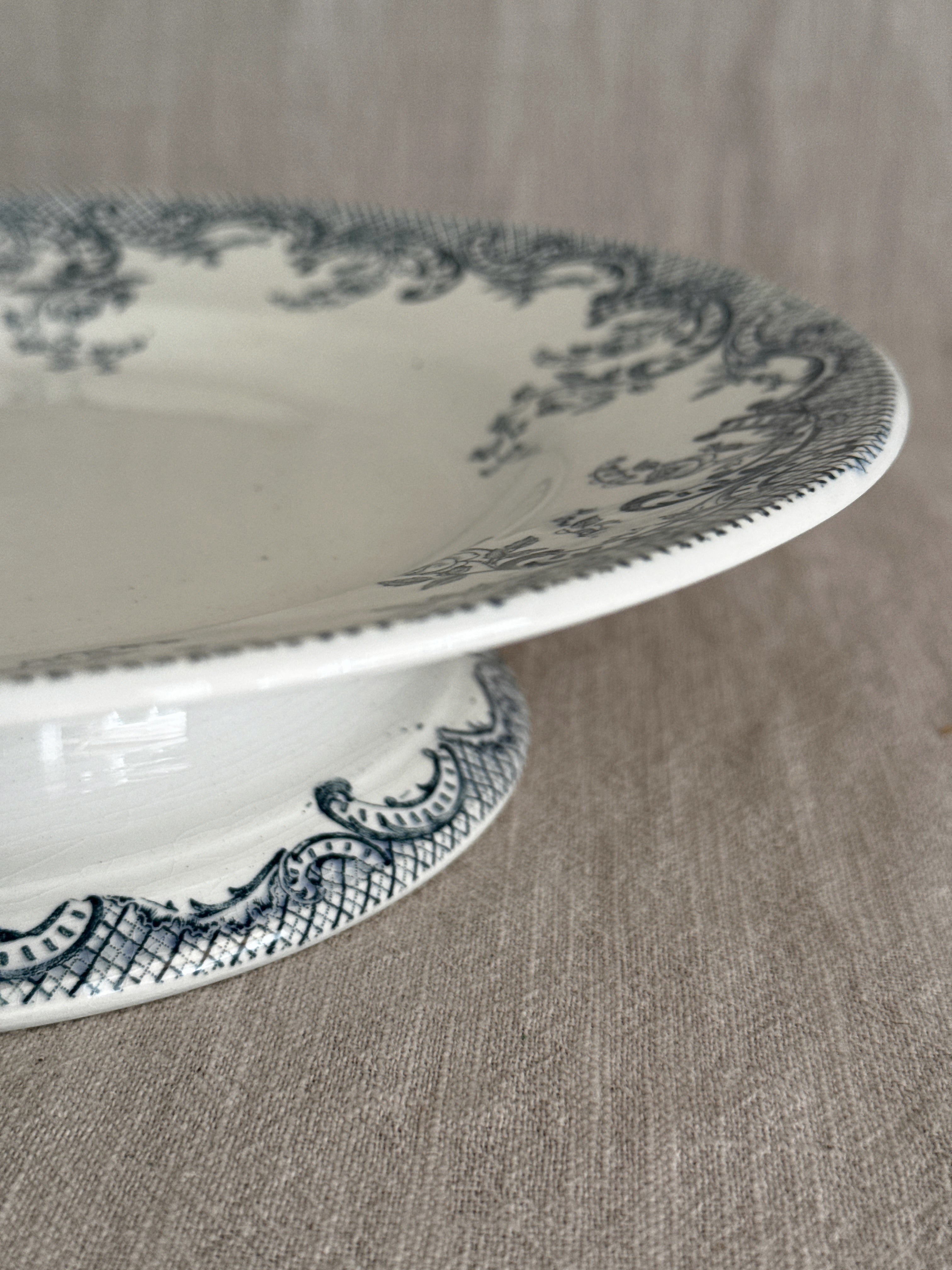 Close-up of the rim edge and pedestal foot of the ironstone compotier, showing the beaded edge and the crisp blue-grey trellis printing