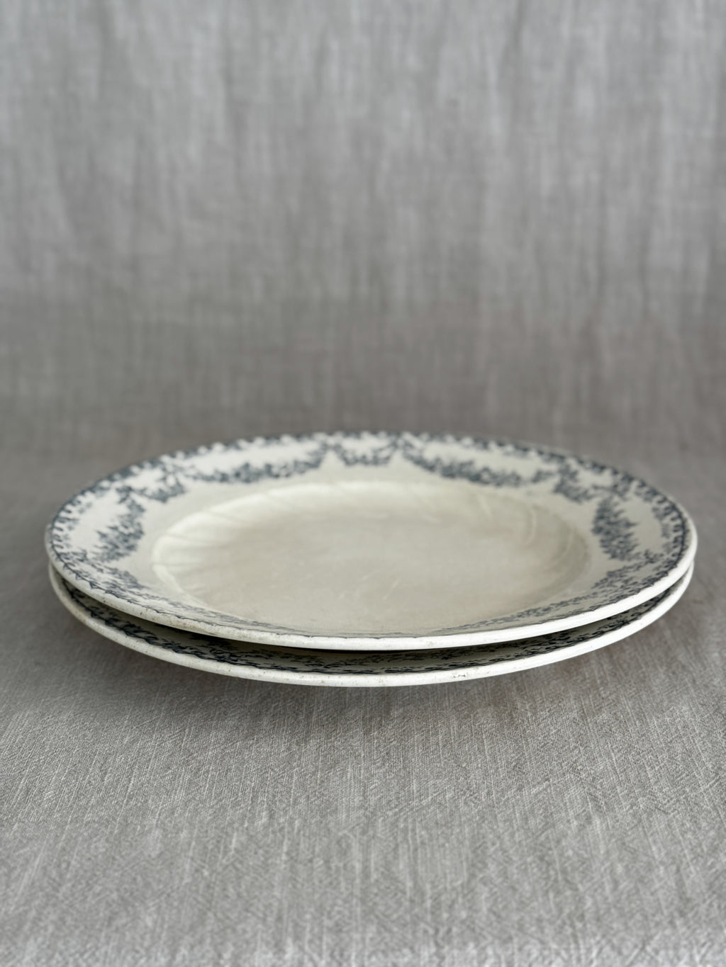 The two faience plates stacked and seen from the side, showing the wide rims and shallow wells