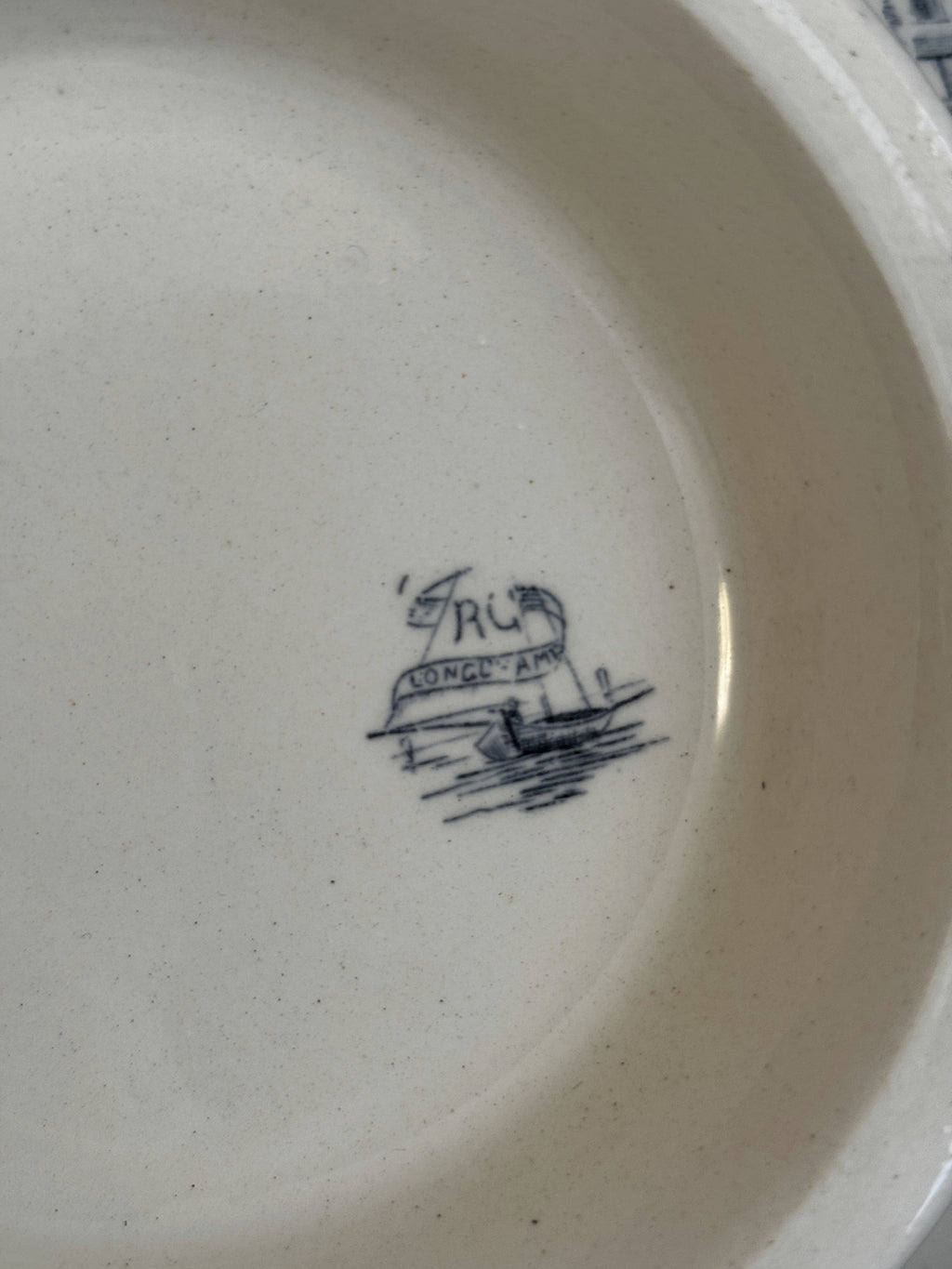 Detail of the Longchamp estampille, a rowing boat with a LONGCHAMP banderole and an interlaced RC monogram in the sail