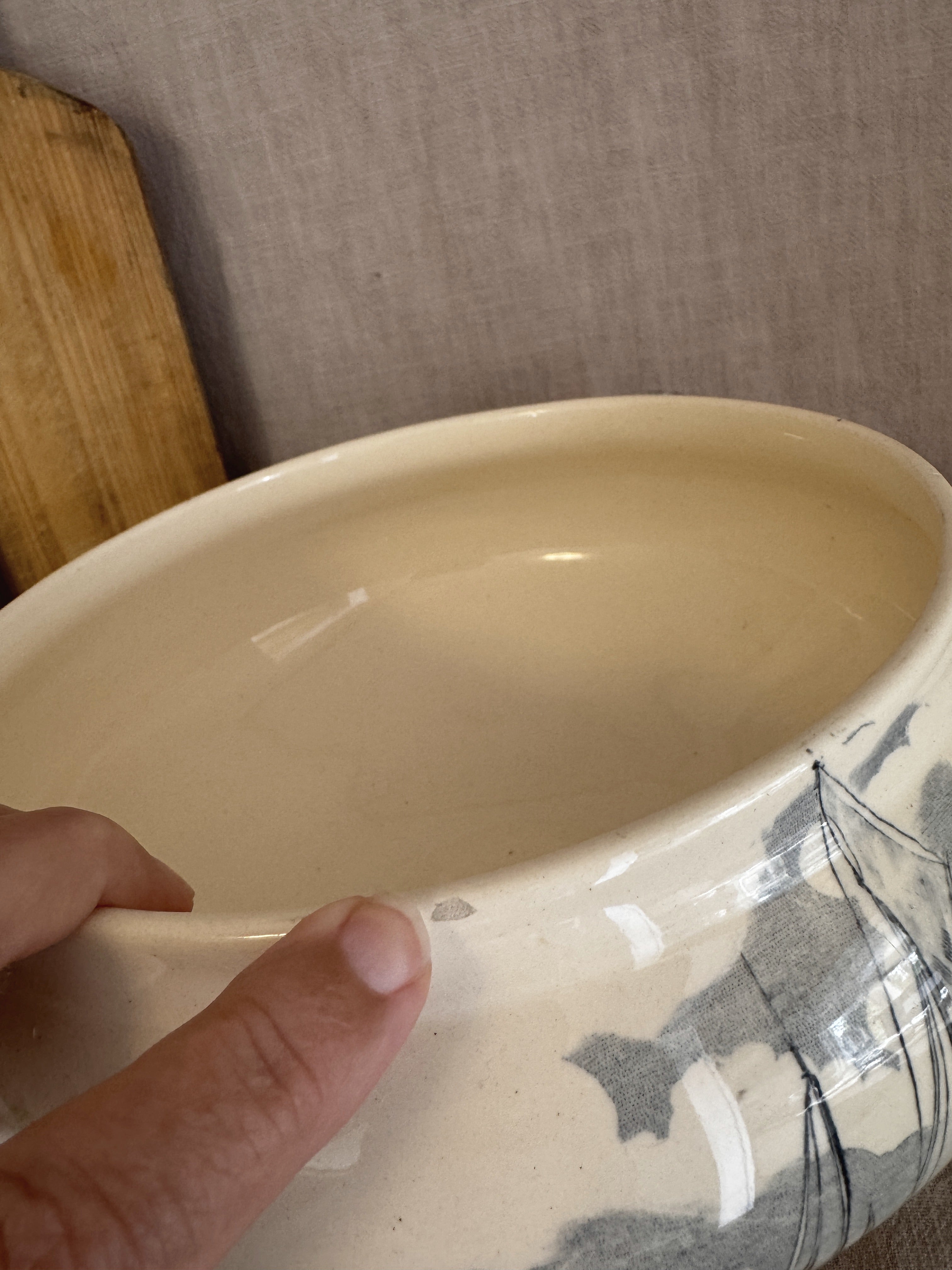 Rim of the antique French tureen seen from above, showing the small nick to the edge