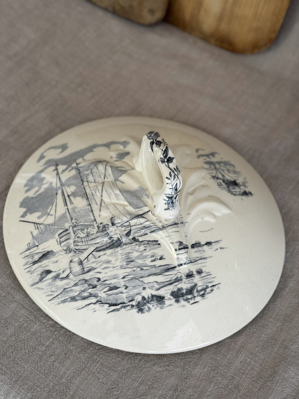 The tureen lid seen from above with its ribbon-loop finial and blue-grey sailing ship transfer