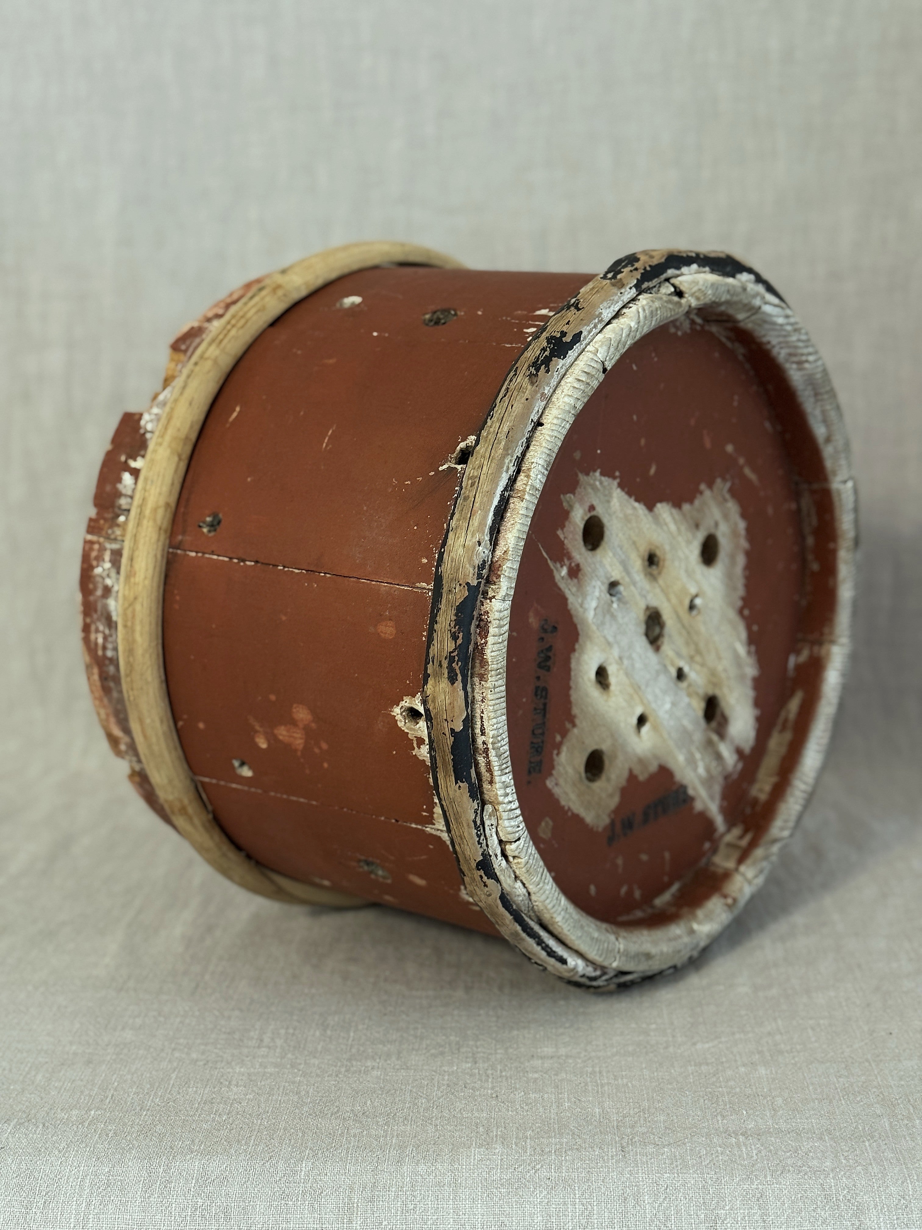 Underside of the Swedish cheese mould with red-painted base, drilled drainage holes and a black J. W. STURE stamp