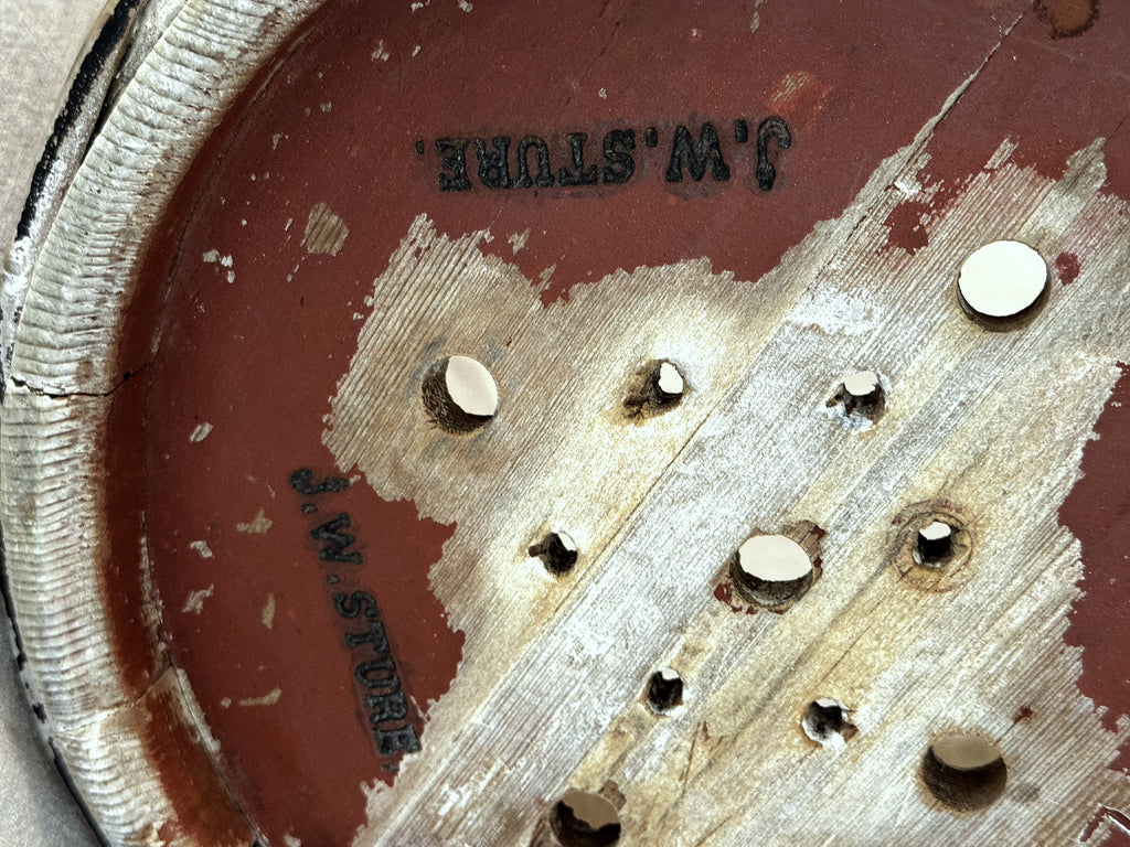 Close-up of the J. W. STURE stamp and drainage holes on the base of the antique Swedish cheese mould