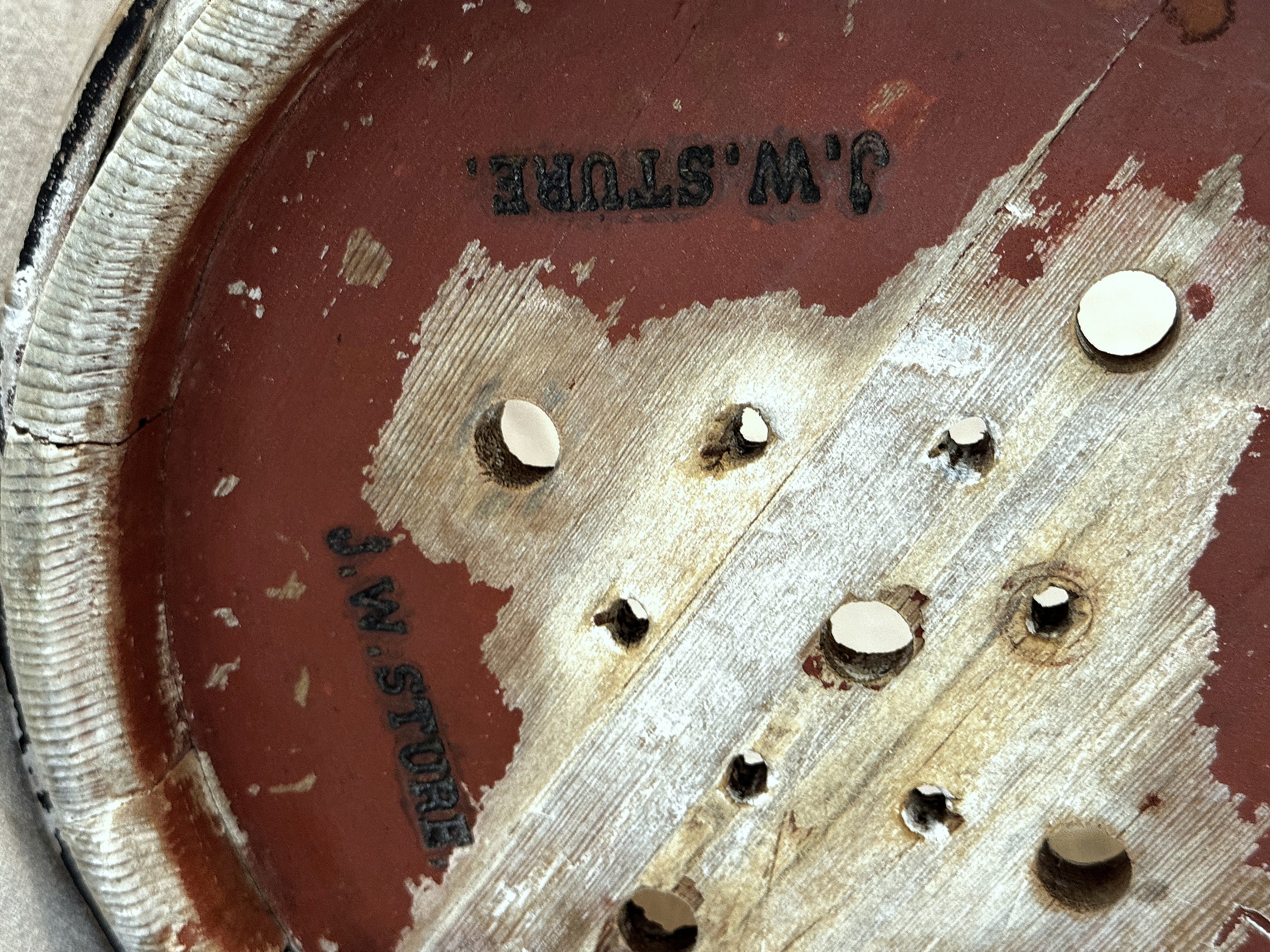 Close-up of the J. W. STURE stamp and drainage holes on the base of the antique Swedish cheese mould