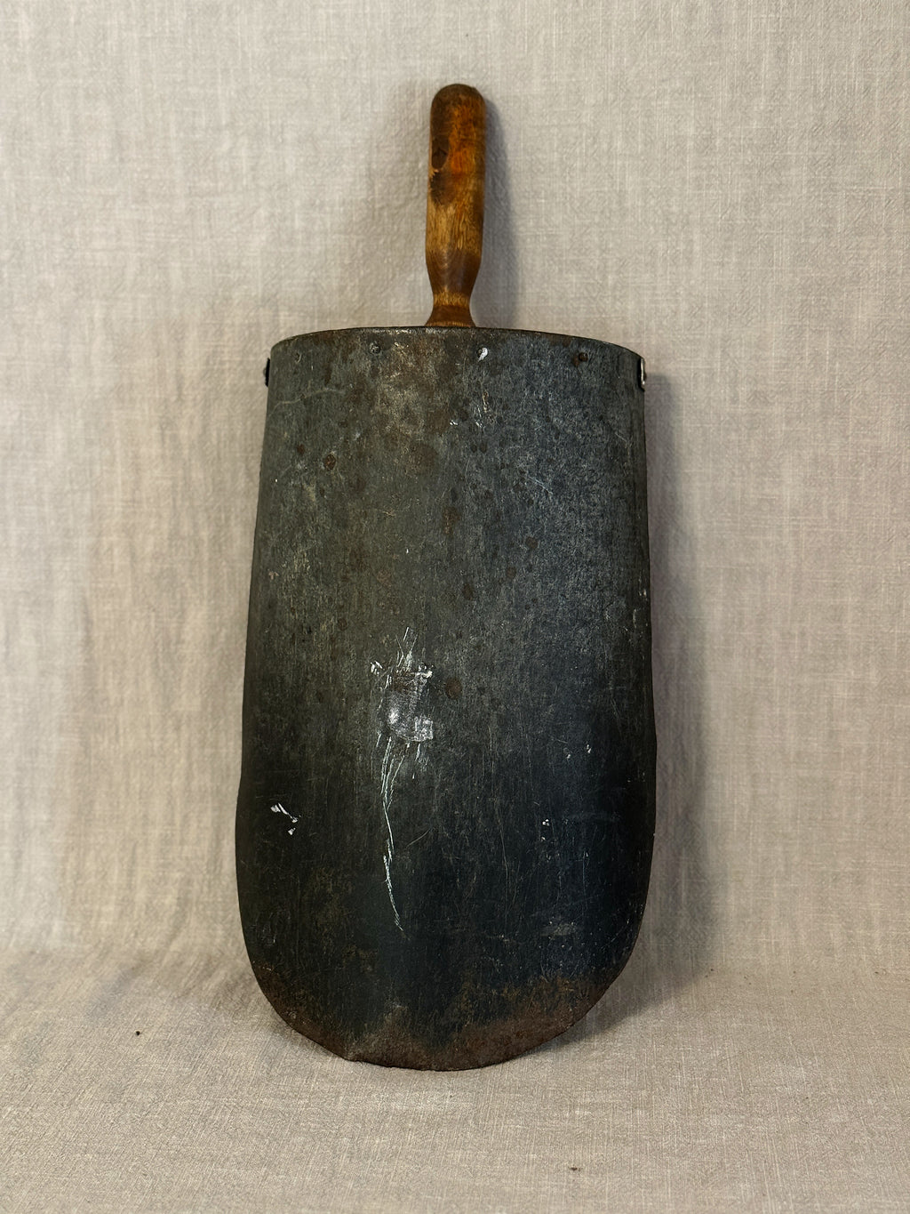 Back of the Swedish grain scoop showing the dark metal blade with rust marks and the wooden handle