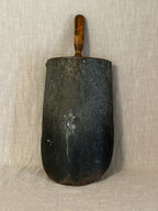 Back of the Swedish grain scoop showing the dark metal blade with rust marks and the wooden handle