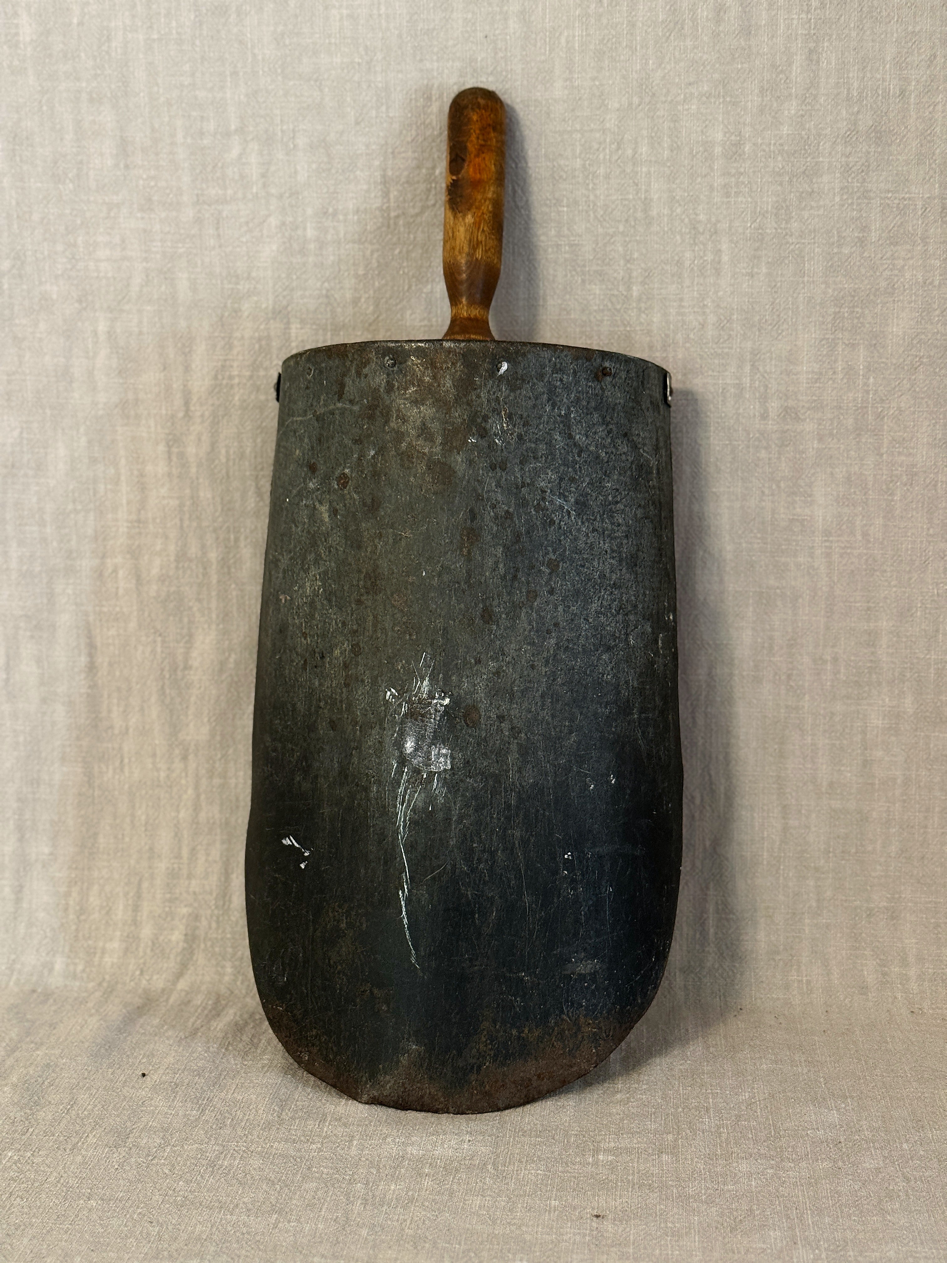 Back of the Swedish grain scoop showing the dark metal blade with rust marks and the wooden handle