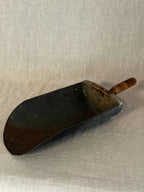 Close-up of the grain scoop blade showing the dark patina and rust marks