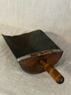 Three-quarter view of the Swedish grain scoop with its shaped wooden back, iron straps and turned handle