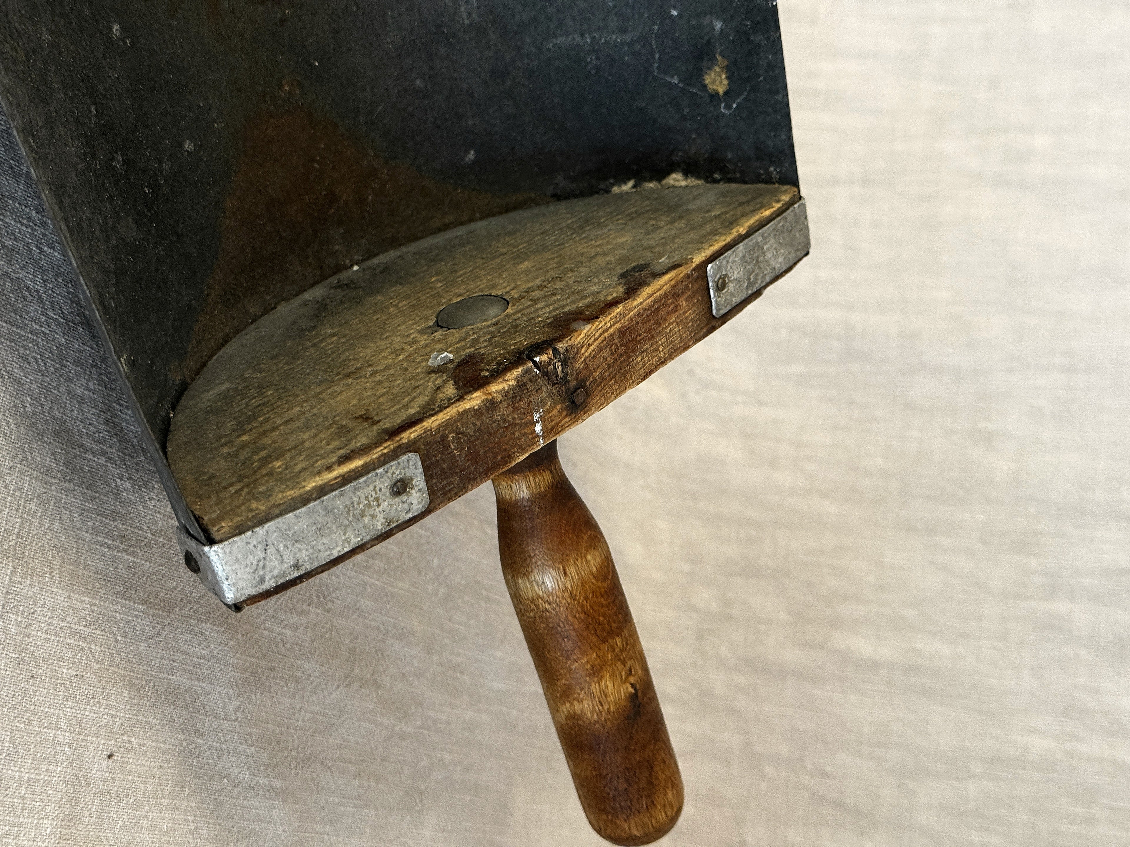 Detail of the grain scoop's wooden back plate with iron straps and the turned wooden handle